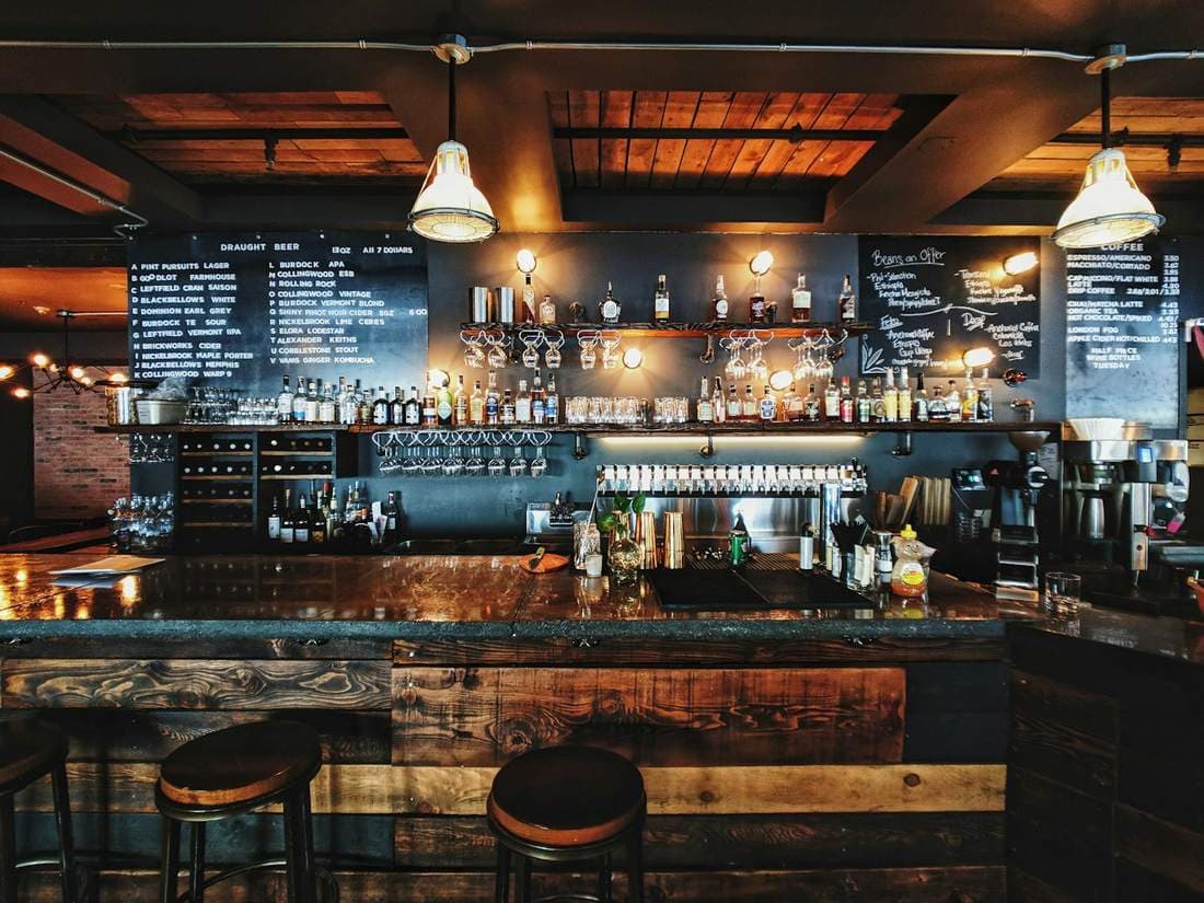 Warmly lit bar with a chalkboard menu